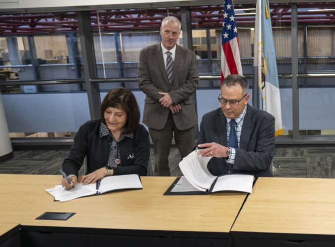 Ahtna President Michelle Anderson and BLM Alaska State Director Steve Cohn sign the agreement, with Ahtna Land Department Special Projects Manager Bruce Cain observing. Bruce played a pivotal role in bringing the agreement to fruition.